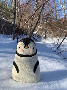 a penguin made out of snow sitting in the snow