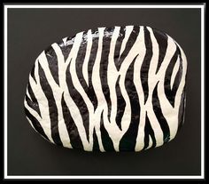 a zebra print rock sitting on top of a black surface