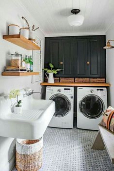 a washer and dryer in a small room with shelves above the washer