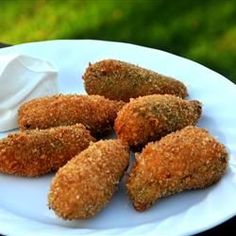 several fried food items on a plate with napkins in the foreground and an advertisement for steve's baked jalapeno poppers