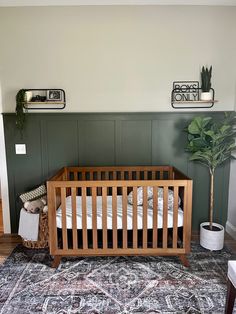 a baby's crib in the corner of a room with green painted walls