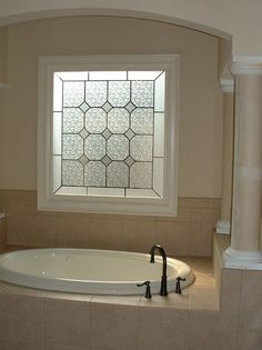 a bath tub sitting under a window in a bathroom