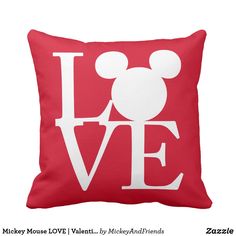 a red pillow with the word love in mickey mouse's head on top of it