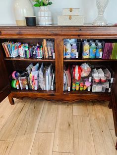 a wooden bookcase filled with lots of books on top of a hard wood floor