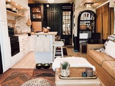 a living room filled with furniture next to a kitchen