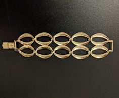 Vintage signed Bergère gold-tone bracelet. Measures 7 inches long, is 1.75 inches wide, and weighs 51 grams.  Shows some signs of wear but overall the piece is in very good condition.  The fold-over clasp is in excellent shape. Bergère jewelry was produced by L. Erbert & Pohls Inc. NY from 1947. The line was sold in higher-end department stores until 1979.  Note: Vintage jewelry often shows signs of wear and age. Condition is in the eye of the beholder so PLEASE refer to pictures to help determine the item's condition to your satisfaction. All items are sold as found. Feel free to ask questions or request additional photos. Retro Yellow Gold Bracelets For Formal Occasions, Retro Yellow Gold Bracelet For Formal Occasions, Vintage Oval Link Gold Bracelet For Formal Occasions, Vintage Gold Bracelet With Oval Link For Formal Occasions, Gold Formal Costume Jewelry Bracelets, Gold Retro Bracelets For Formal Occasions, Gold Costume Jewelry Bracelets For Formal Occasions, Gold Costume Jewelry Bracelets For Formal Events, Formal Hallmarked Metal Chain Bracelet