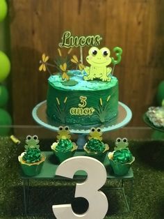 a birthday cake with green frosting and frog decorations