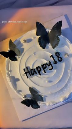 a birthday cake with white frosting and black butterflies on the top that says happy 8th