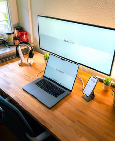 an open laptop computer sitting on top of a wooden desk next to a desktop computer