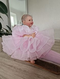 Introducing our incredibly puffy soft pink baby dress, specially designed to make your little one shine like a star! This enchanting dress features large puffy sleeves that add an adorable touch. The shiny fabric adds a delightful sparkle, making your little princess feel like royalty. Adorned with delicate 3D flowers and petals, this dress not only adds a charming touch but also creates a whimsical and dreamy look. Handcrafted with love, this dress is destined to make magical memories. Perfect for special occasions or simply creating picture-perfect moments, this dress is a must-have for your little fashionista. The dress can be sewn in such colors as white, ivory, light beige, light blue, delicate peach, blush, lavender, yellow. you can order a headband and booties as a set for the dress Pink Princess Fairy Dress For Pageant, Pink Ruffled Princess Dress For First Birthday, Pink Princess Baptism Dress For First Birthday, Pink Organza Tutu Dress For Baptism, Pink Organza Princess Dress With Ruffles, Cute Pink Princess Dress For Baptism, Cute Pink Tulle Baptism Dress, Sweet Pink Princess Dress With Ruffles, Organza Tutu Dress With Ruffles For First Birthday