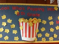 a bulletin board with popcorn in the middle and writing on it that says look who's popping into 5th grade