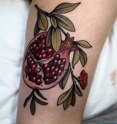 a woman with a tattoo on her leg has a pomegranate