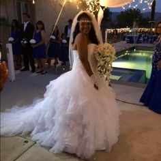 a woman in a wedding dress standing next to a pool with sparklers on it