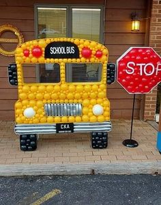 a school bus made out of oranges is parked in front of a stop sign