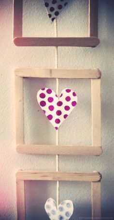 three wooden frames with hearts hanging from them