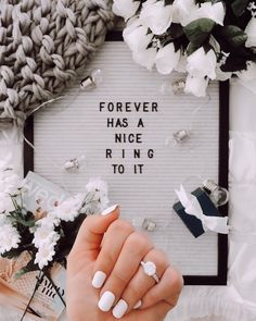 a woman's hand holding a ring with the words forever has a nice ring to it