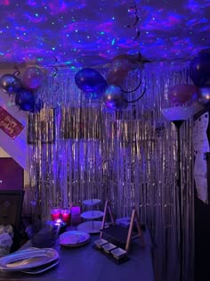 a party room with balloons and streamers hanging from the ceiling, blue lights in the background