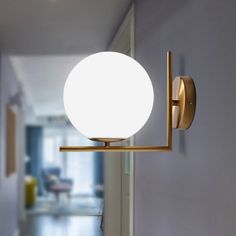 a light that is on the wall next to a door with a hallway in the background