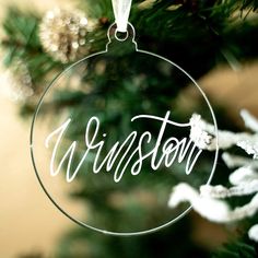 a glass ornament hanging from a christmas tree with the word wisconsin on it