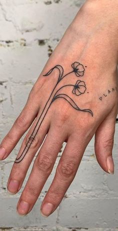 a woman's hand with a flower tattoo on it