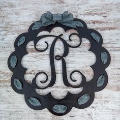 a metal monogrammed sign with the letter j in it's center on a wooden background