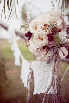 a bridal bouquet hanging from a tree branch