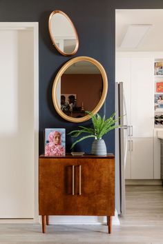 a living room with a mirror on the wall and a wooden cabinet in front of it