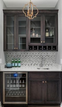 a kitchen with dark wood cabinets and white counter tops, an open wine cooler in the center