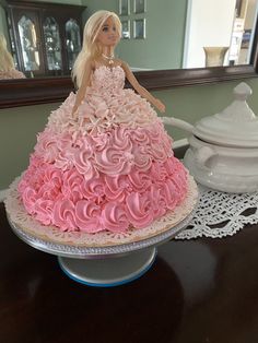 a barbie doll sitting on top of a cake