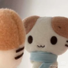 two small stuffed animals are standing next to each other