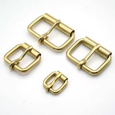 four brass metal buckles on white background