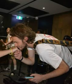 two people are touching each other's fingers in front of microphones and music equipment