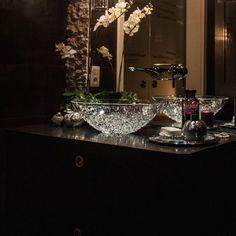 a bathroom sink sitting under a mirror in front of a wall mounted faucet