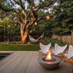 an outdoor fire pit with chairs around it