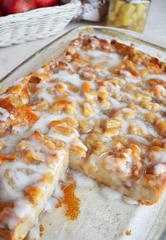 a close up of a cake on a pan with apples in the backgroud