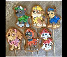 there are many decorated cookies that look like puppies and firemen on sticks in the shape of dogs