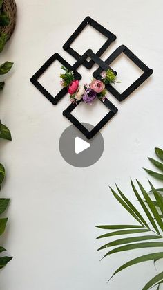 a wall clock with flowers on it next to plants