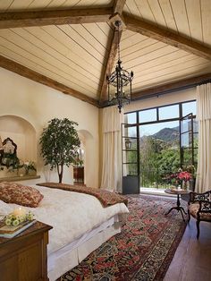 a bedroom with a large bed and a chandelier hanging from it's ceiling