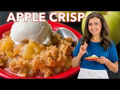 a woman holding a plate with some food on it and an apple crisp in the background