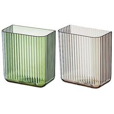 two glass vases sitting next to each other on a white background, one green and the other clear