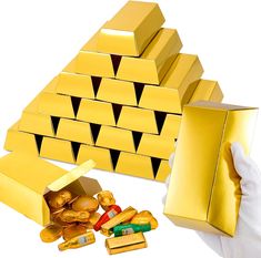 gold bars are stacked on top of each other in front of a pyramid shaped box