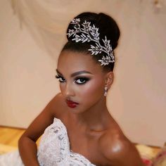 a woman in a wedding dress wearing a bridal hair piece with leaves on it