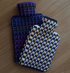 two crocheted gloves sitting on top of a wooden floor