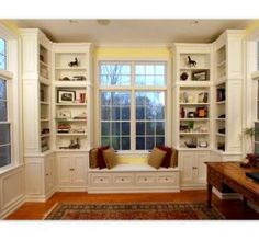 a living room filled with lots of white furniture and windows covered in bookshelves