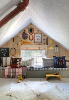 a room with a couch, window and rugs on the floor in front of it