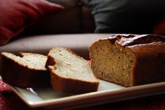 sliced loaf of bread sitting on top of a white plate next to a red pillow