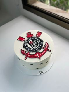 a white and red cake sitting on top of a window sill