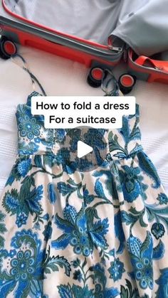 an open suitcase and dress on a bed with the words how to fold a dress for a suitcase