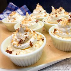 cupcakes with white frosting and toppings on a tray