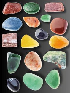 several different types of sea glass on a black background